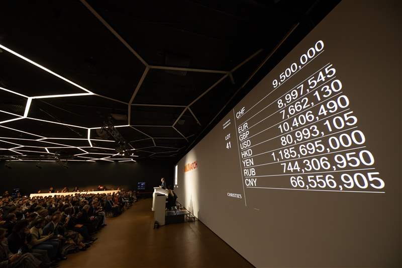 墻上的投影以不同貨幣捕捉 Only Watch 2021 的投標過程。